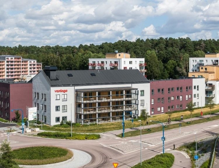 Äldreboende i vit byggnad med inglasade balkonger