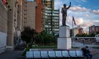 A boy speaks on the phone underneath a 10-foot-high statue of former U.S President Bill Clinton on Bill Clinton Boulevard in 2019 in Pristina, Kosovo.
