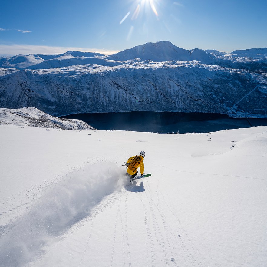 en &aring;kare i pudrig offpist med fjorden nedanf&ouml;r en solig dag i Narvik