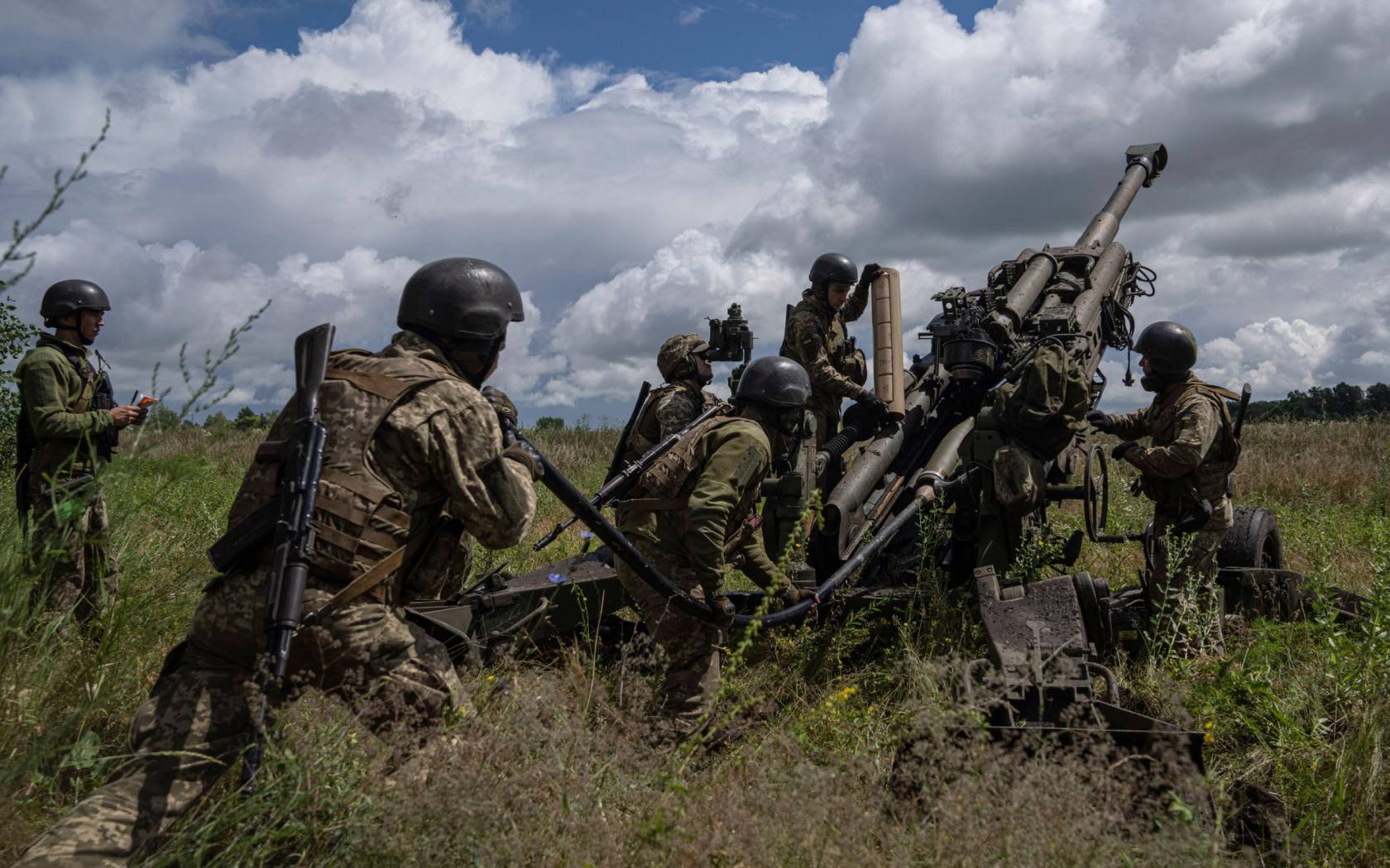 Ukrainian servicemen prepare to fire at Russian positions from a U.S.-supplied M777 howitzer in Kharkiv region, Ukraine.