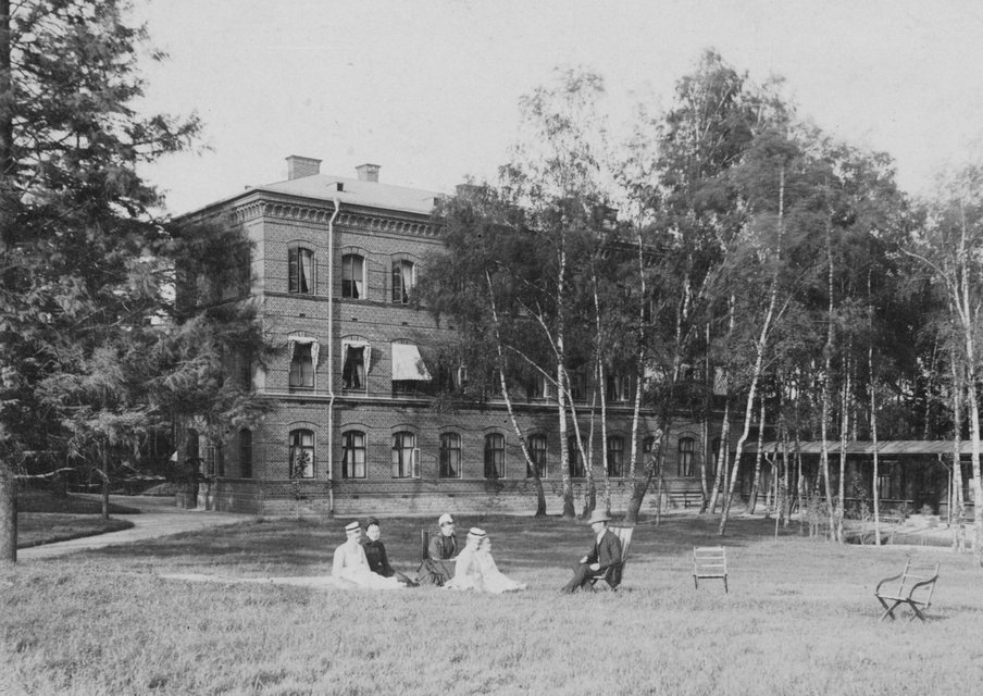 Sköterskeelever sitter i gräset på Sophiahemmets baksida, 1890.