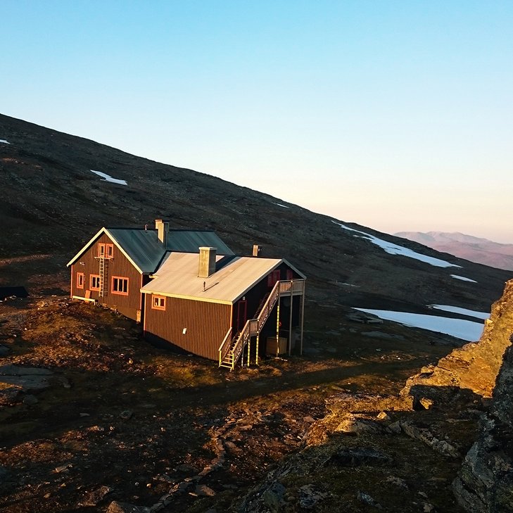 L&aring;ktatj&aring;kko fj&auml;llstation i midnattssolen med en bl&aring; och rosa himmel