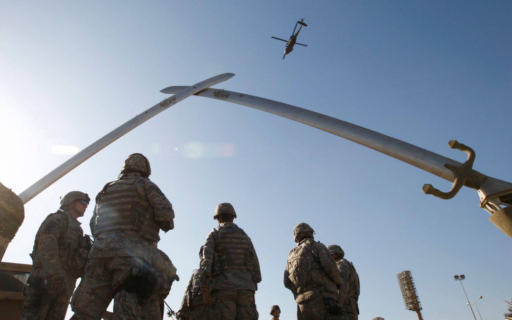 US soldiers wait before going out on a mission under the Crossed-Sabers – a towering 160-tonne, bronze monument of two crossed swords held in Saddam's hands, at the fortified Green Zone in Baghdad, December 7, 2008.