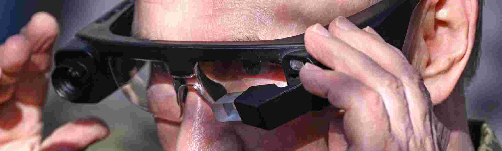 Vladimir Putin tries on thermal imaging goggles as he inspects Russian weapons and equipment.