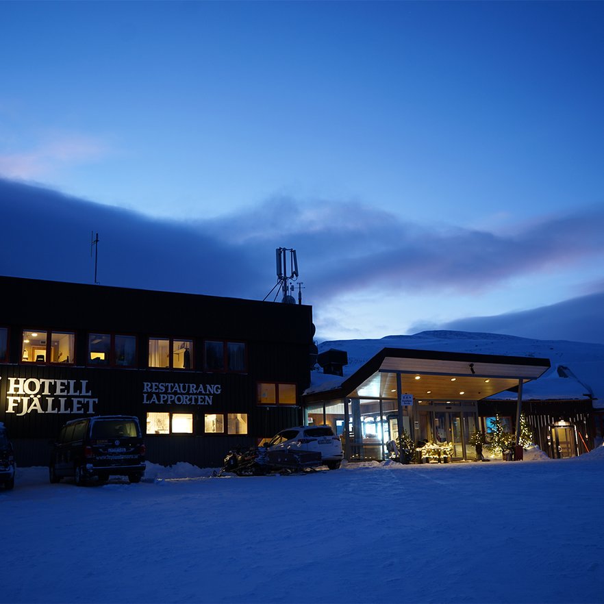 A mountain hotel beneath the dark blue sky of the polar night