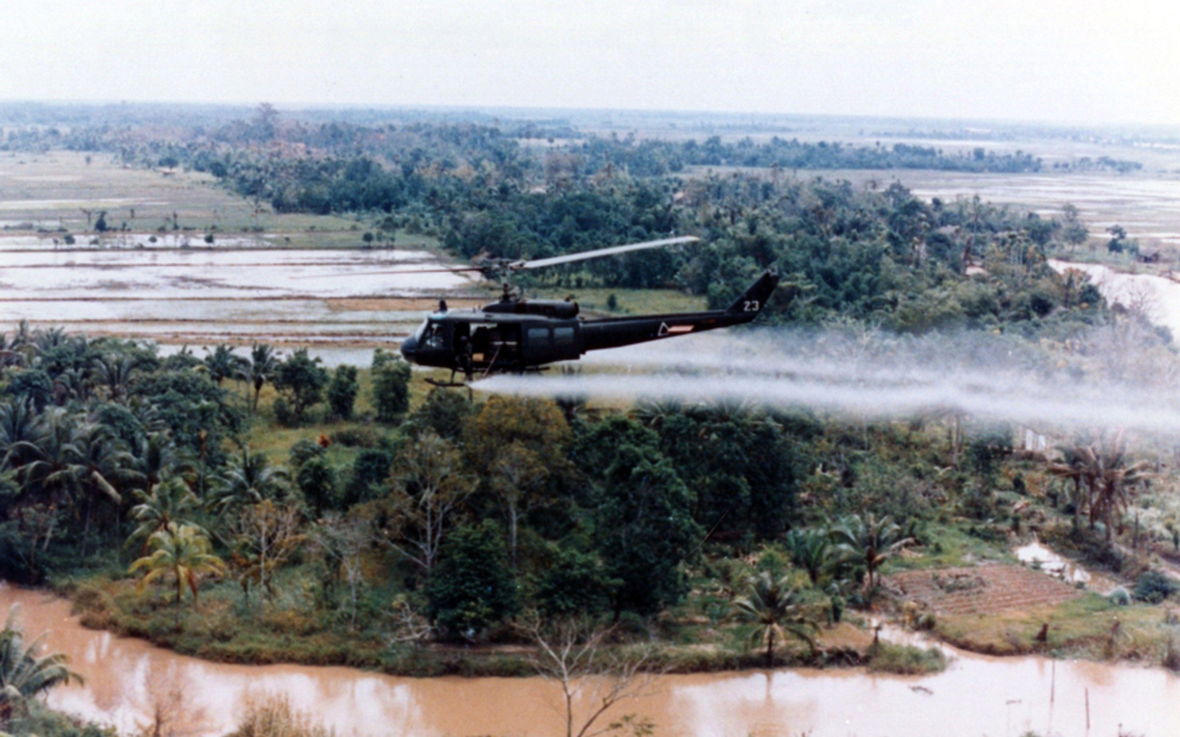 A US Huey helicopter spraying agent orange during Operation Ranch Hand, c. 1963.