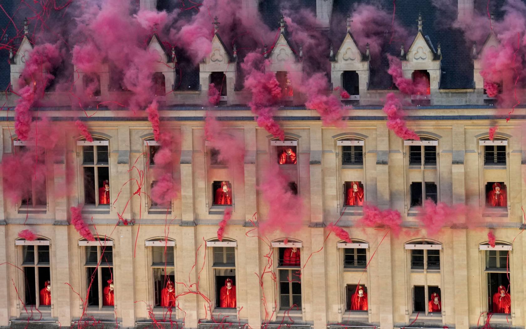 Smoke billows near windows as performers participate in the opening ceremony of the 2024 Paris Olympics.