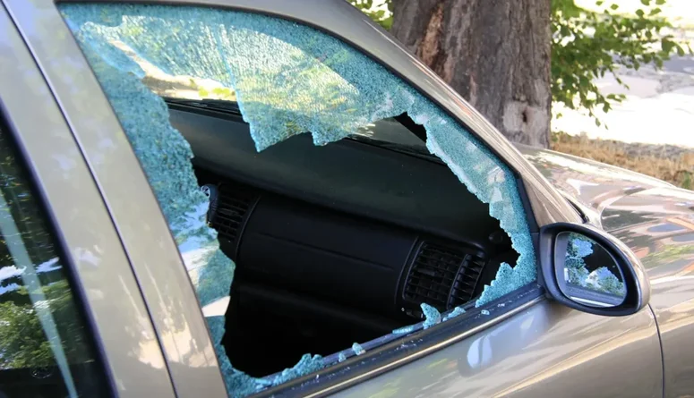 En parkerad bil med krossad ruta.