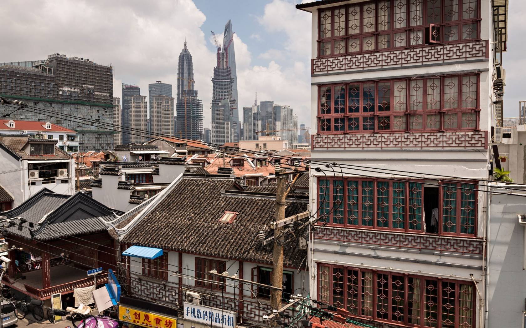 Traditional chinese tile roofs contrast the modern skyline of Shanghai.