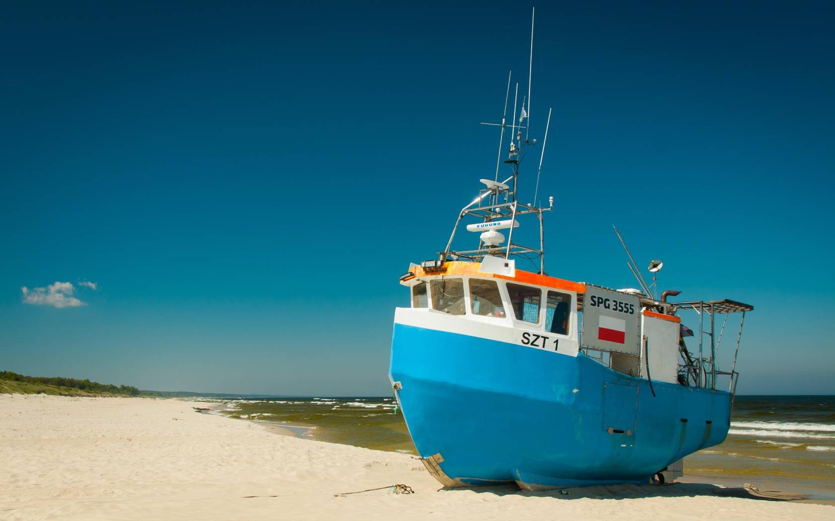 Fishing boat on a sandy beach near Krynica Morska, Poland.