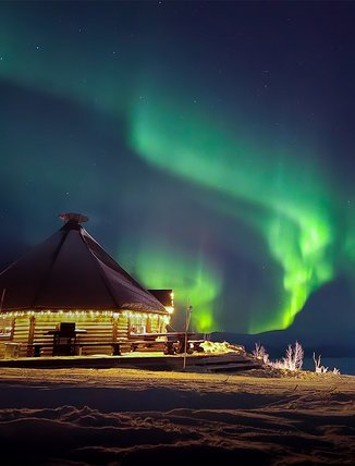 The Northern Lights dance across Rakkaskåten in Björkliden