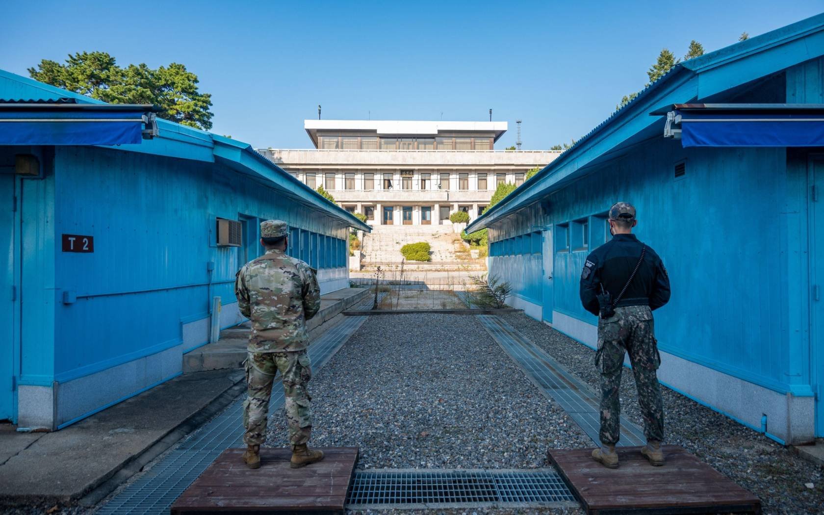 An American and South Korean soldier stand at a border outpost.
