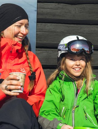 A guide is taking a break in the sun with a ski student