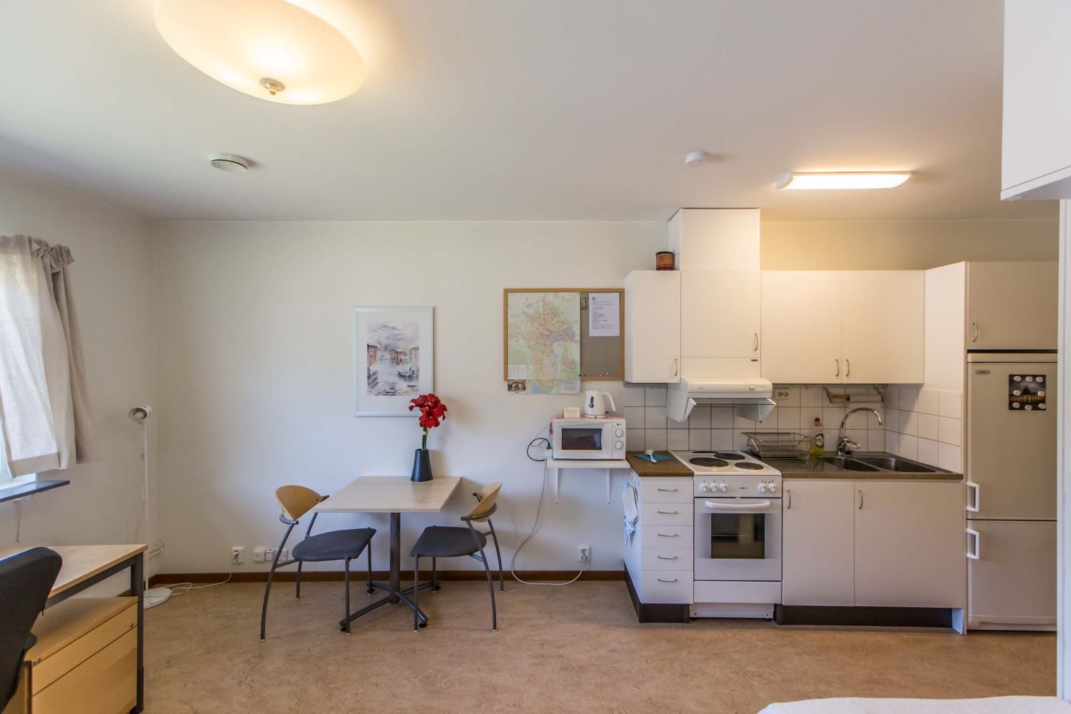 Studentroom with kitchen. Stove, oven, sink, refrigerator, freezer, microwave, table, chairs and notice board.
