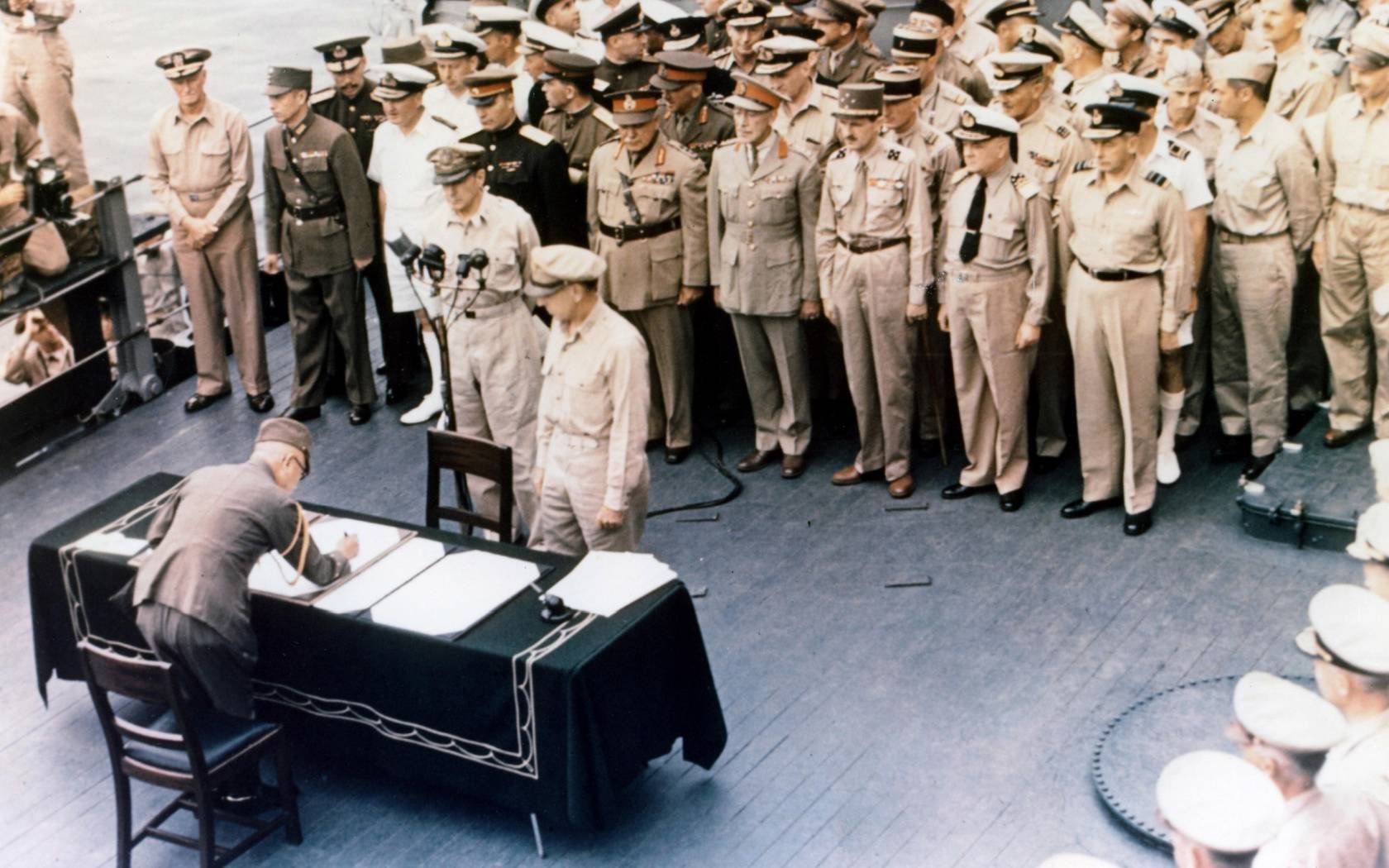 General Douglas MacArthur watches as representatives of Japan stand aboard USS Missouri prior to the signing of the Instrument of Surrender ending the Second World War.