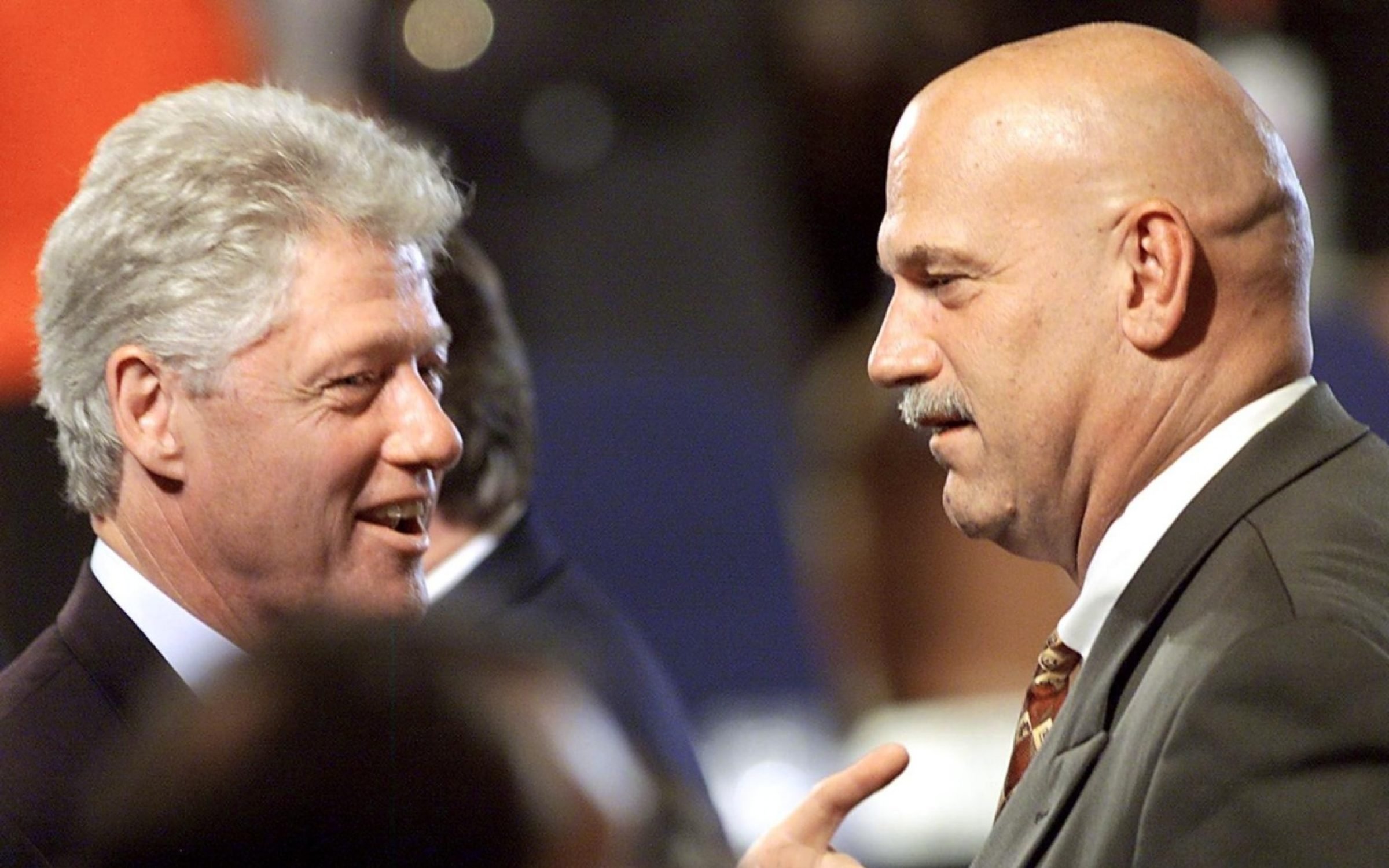 Jesse Ventura speaks with Bill Clinton at the National Governors' Association Convention, 1999. Credit: Stephen Jaffe / AFP via Getty Images.