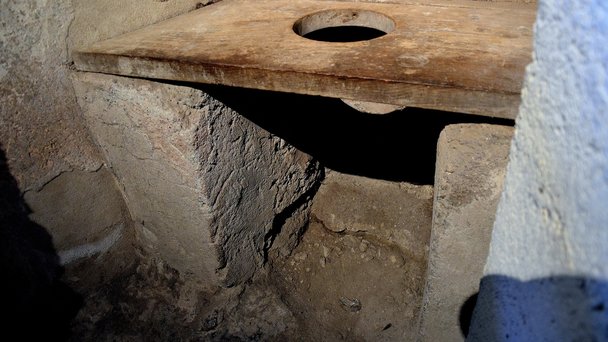 Toaletterna i Pompejis privathus var inte knutna till avloppsnätet. I stället hade man ofta en tunna under eller ett djupt schakt, en så kallad sjunkbrunn, ned i den porösa berggrunden. Här en sådan toalett i stadens största bordell. Foto: Carole Raddato/Wikimedia Commons