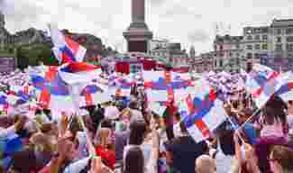 Supporters wave England flags during the Women&#039;s Euro final 2022 in Trafalgar Square.