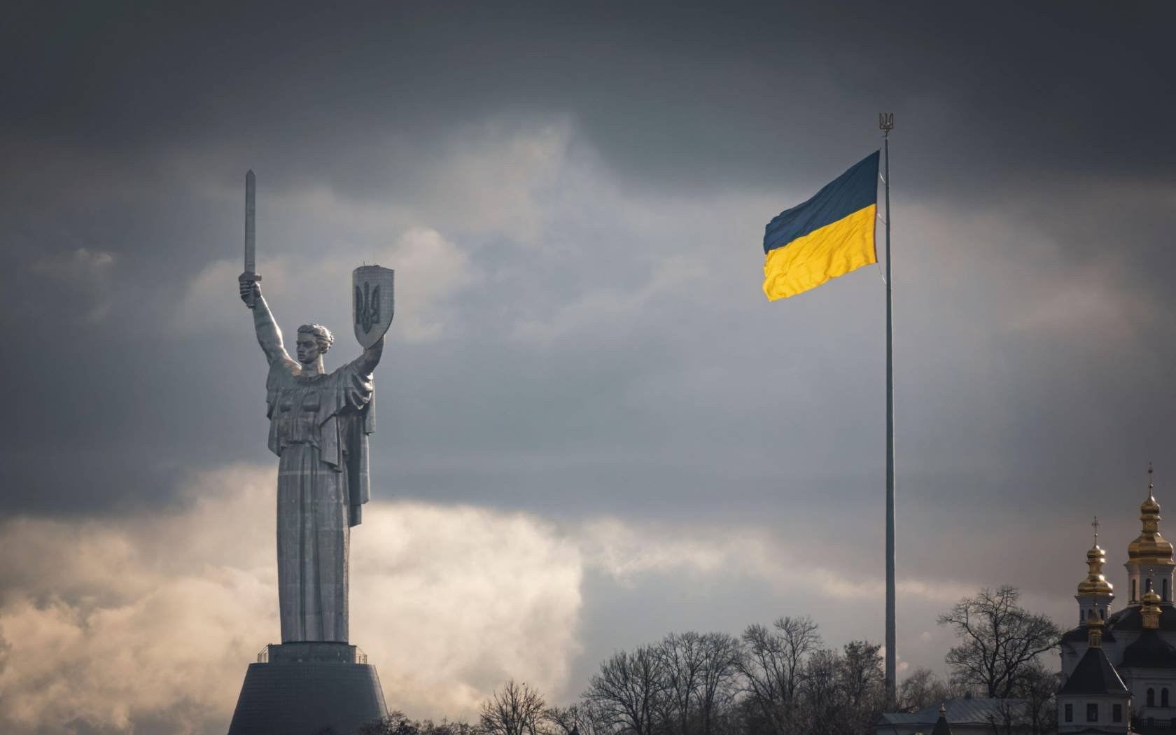 The Ukrainian flag and Motherland monument on the right bank of Dnipro river.