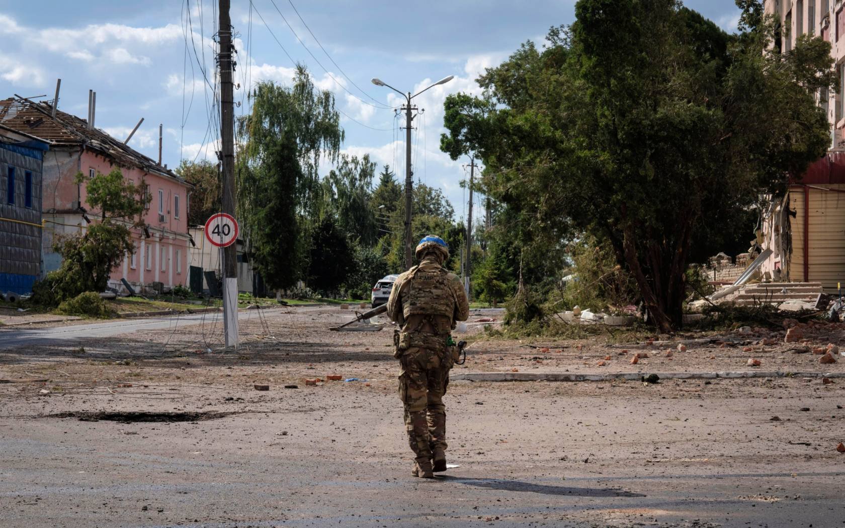 A Ukrainian soldier walks through the centre of Sudzha in Kursk.