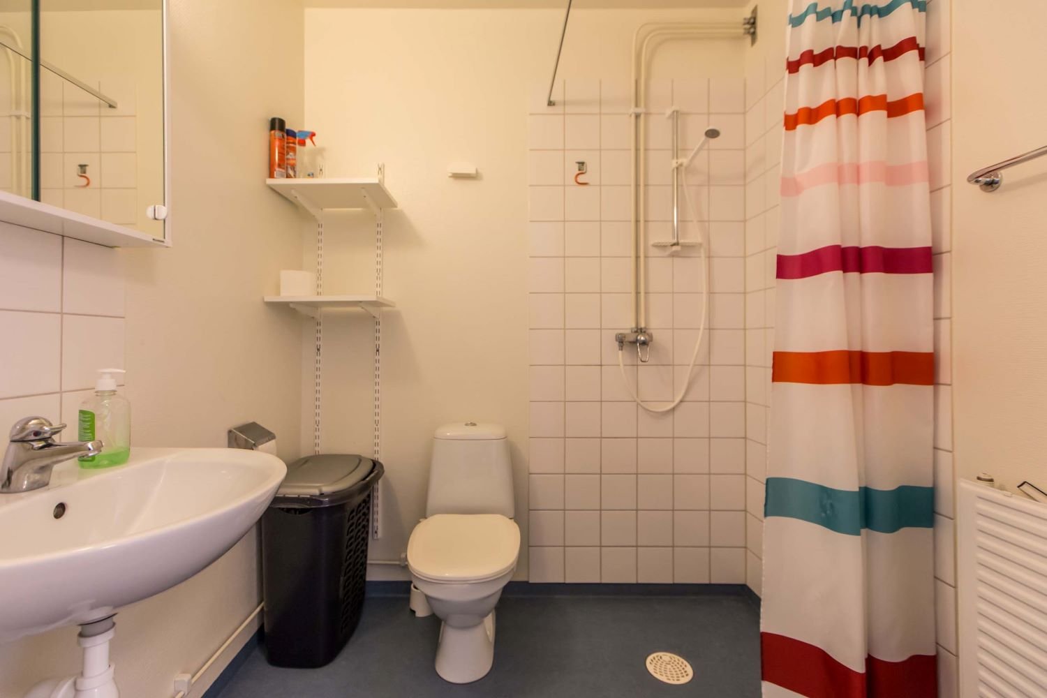 Tiled bathroom with sink, wc and shower.