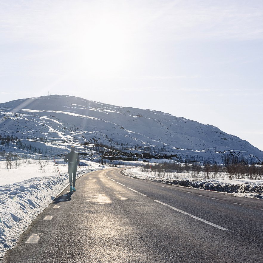 en l&ouml;pare springer p&aring; v&auml;gen en solig vinterdag