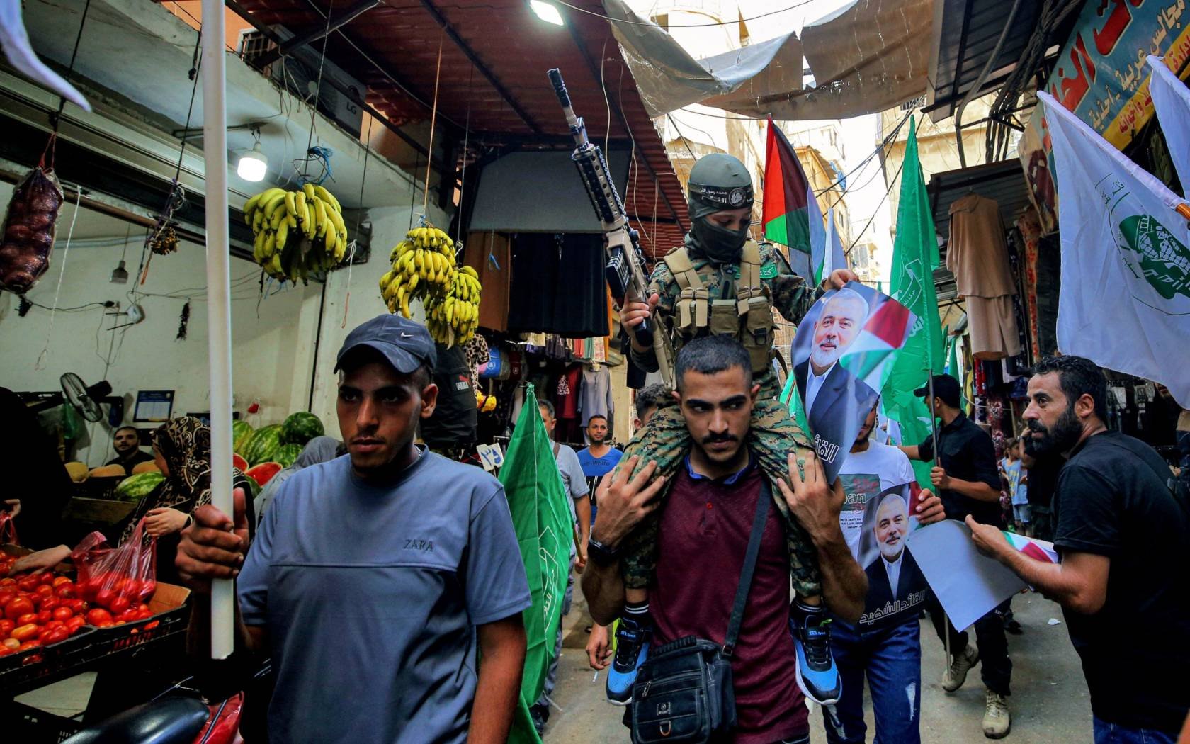 Palestinian refugees wave flags and hold pictures of the leader of the Hamas leader Ismail Haniyeh in Beirut.