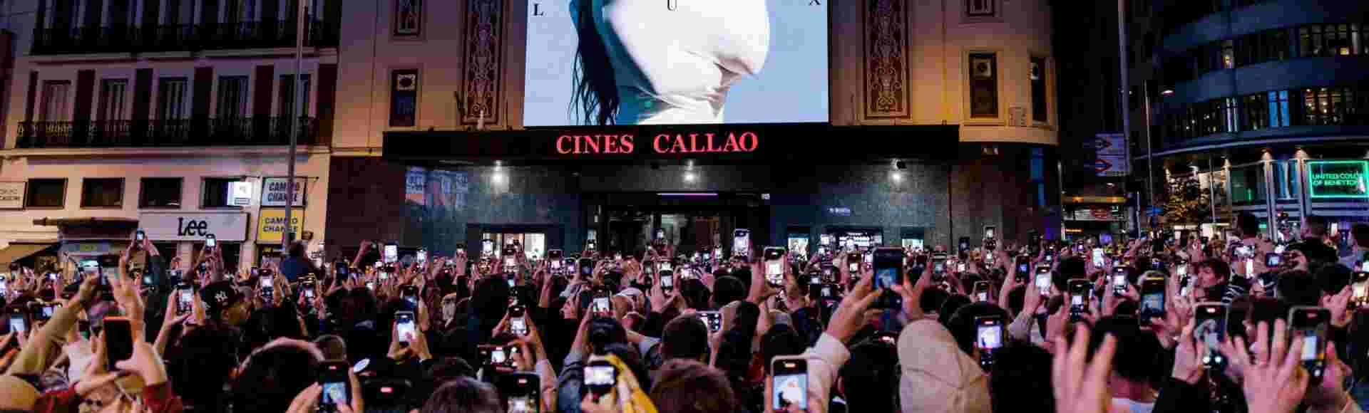 A crowd looks at the cover of Rosalia's new album, 'Lux', in Madrid.