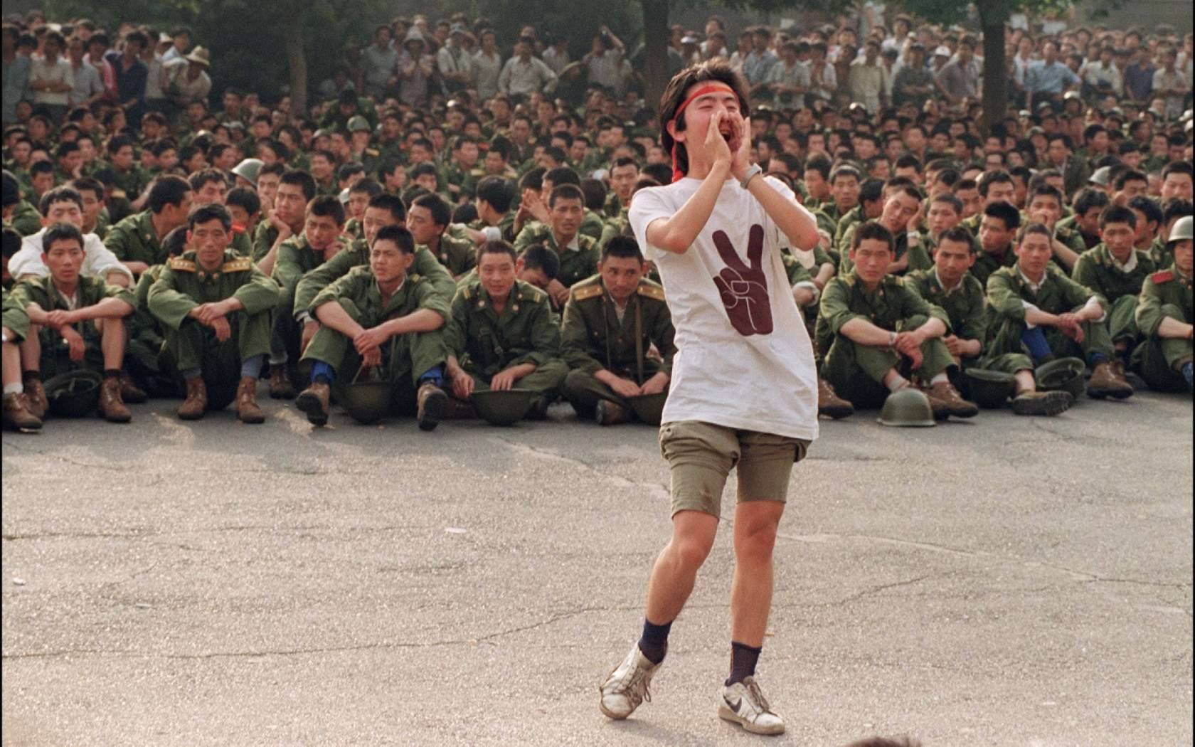 A dissident student asks soldiers to go back home as crowds flooded into central Beijing 03 June 1989.