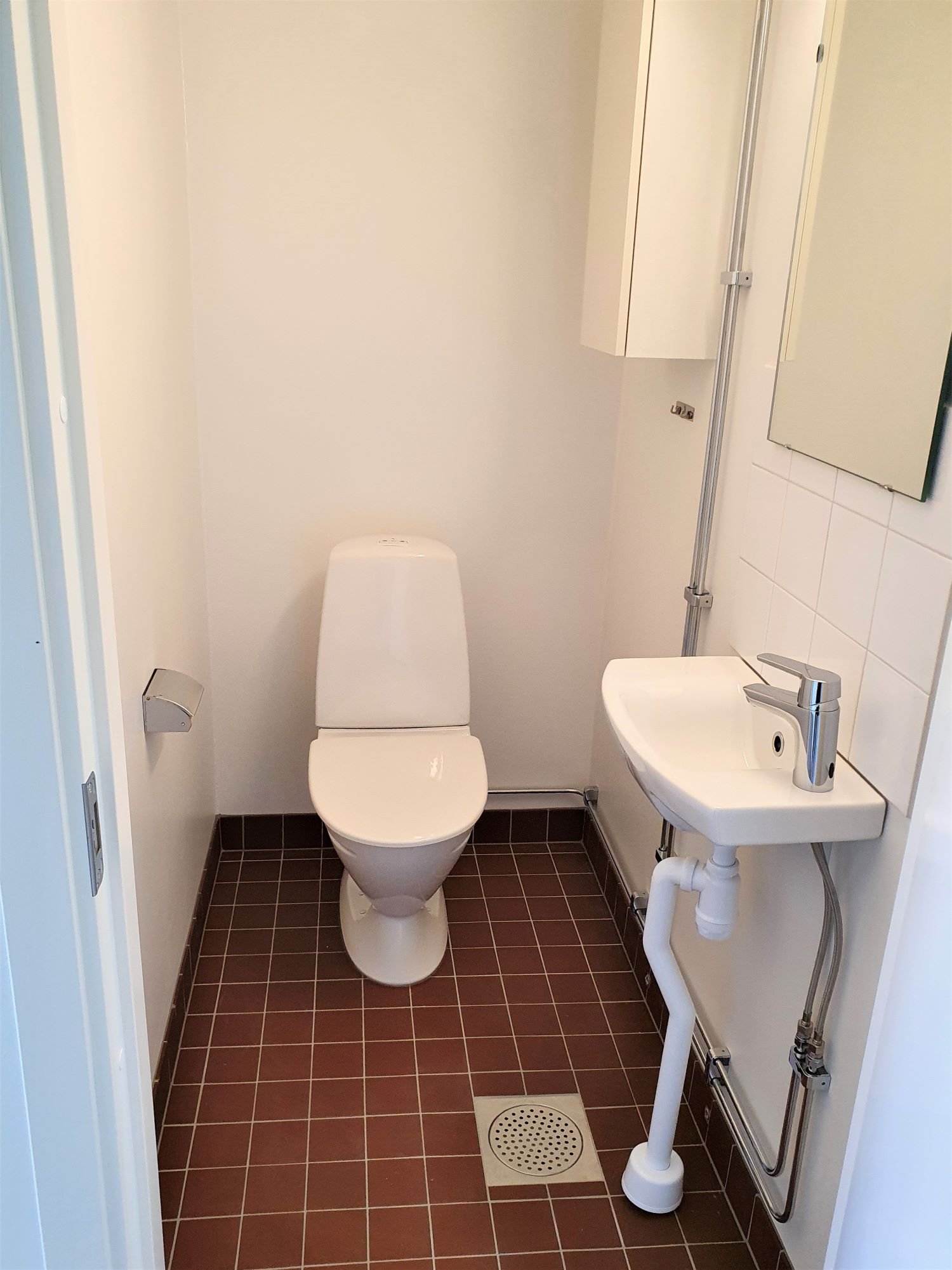 Tiled WC with toilet and sink.