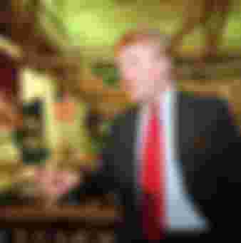 Donald Trump poses for photos above the floor of the New York Stock Exchange after taking his Trump Plaza Casino public in New York on June 7, 1995.