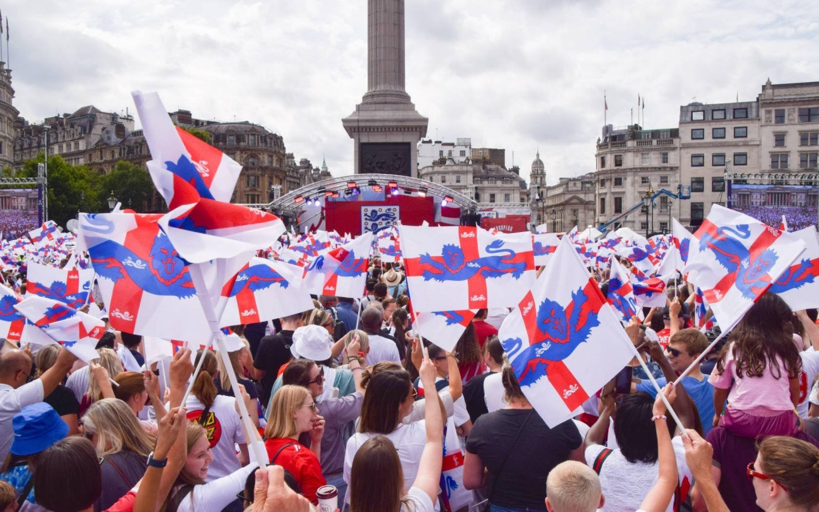 Supporters wave England flags during the Women's Euro final 2022 in Trafalgar Square.