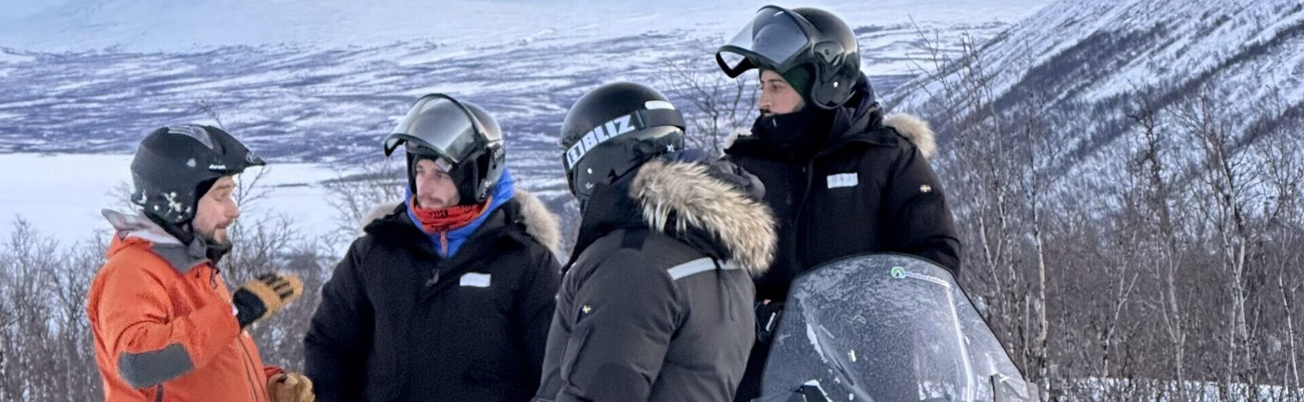 Outback Abisko guide briefing guests during a guided snowmobile tour in Abisko, Swedish Lapland.