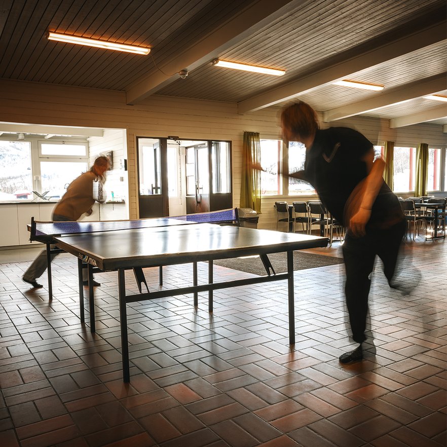 tv&aring; personer spelar pingis i servicehuset vid campingen
