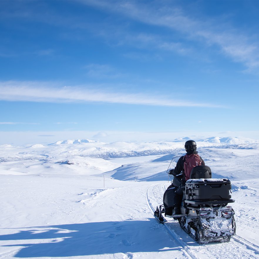 sn&ouml;skoterf&ouml;rare blickar ut &ouml;ver det milsvida vinterlandskapet uppe p&aring; fj&auml;llet