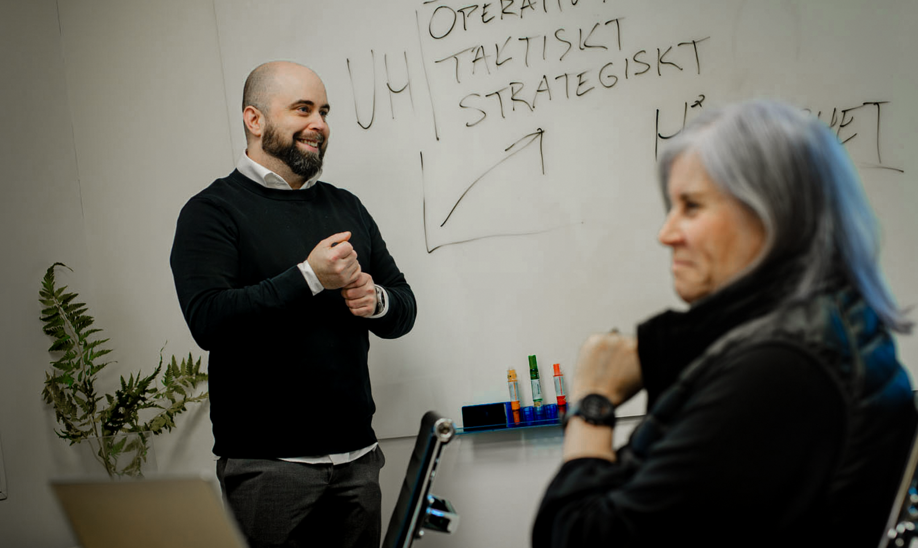 Person presenterar vid whiteboard under m&ouml;te.
