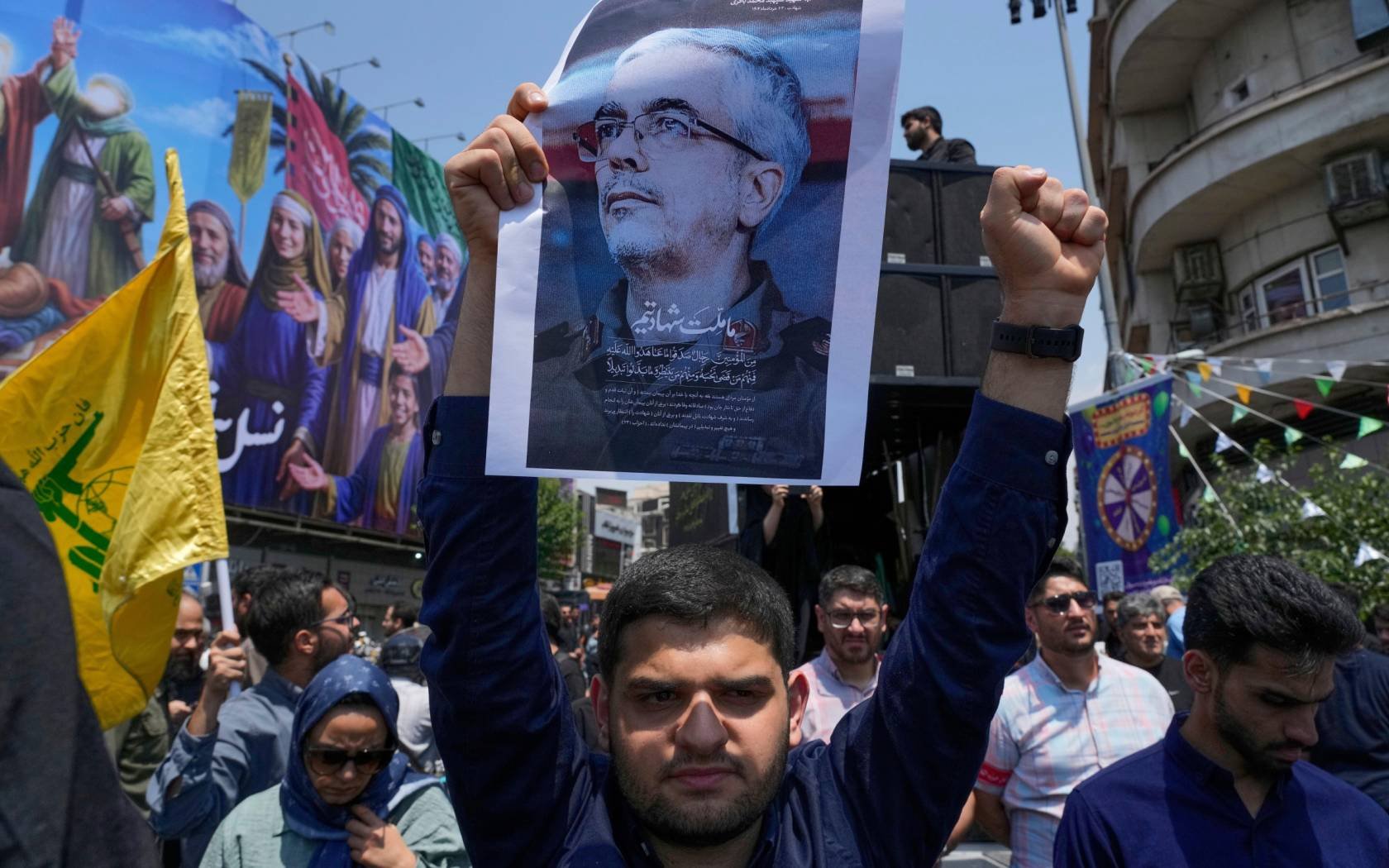 An Iranian protester holds up a poster of Mohammad Bagheri, the chief of Iran's military, who was killed in an Israeli strike.