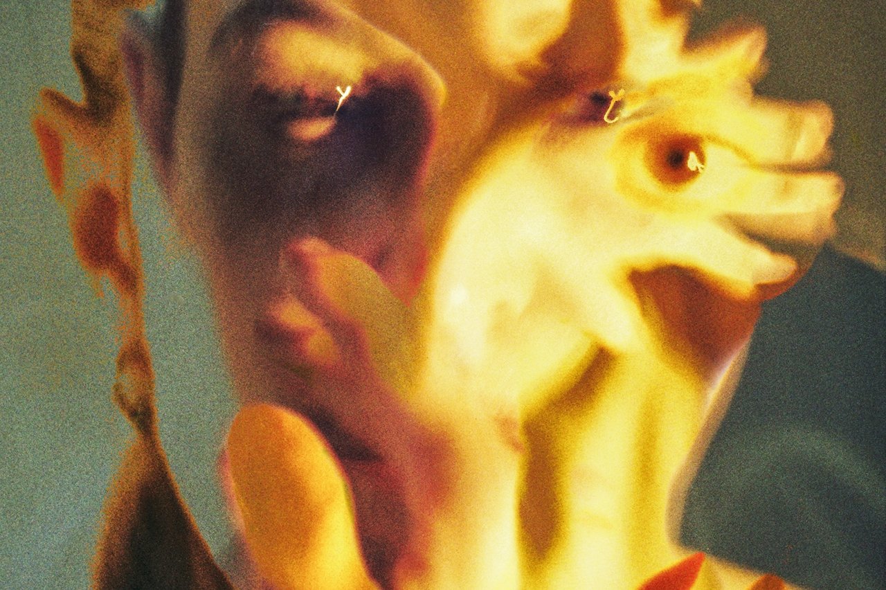 Närbild på dansare med händerna framför ansiktet i rörelse.