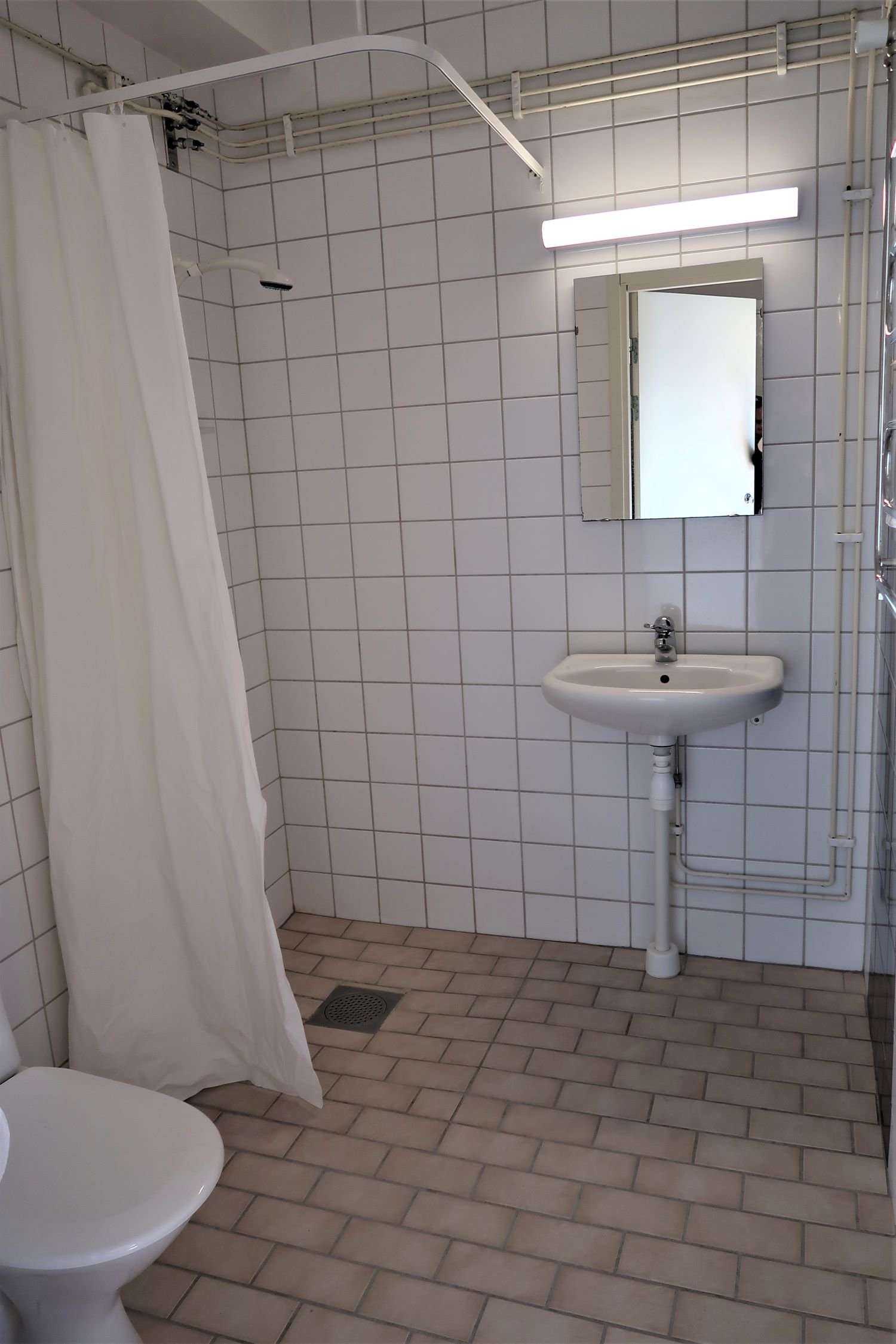 Tiled bathroom with wc, sink and shower.