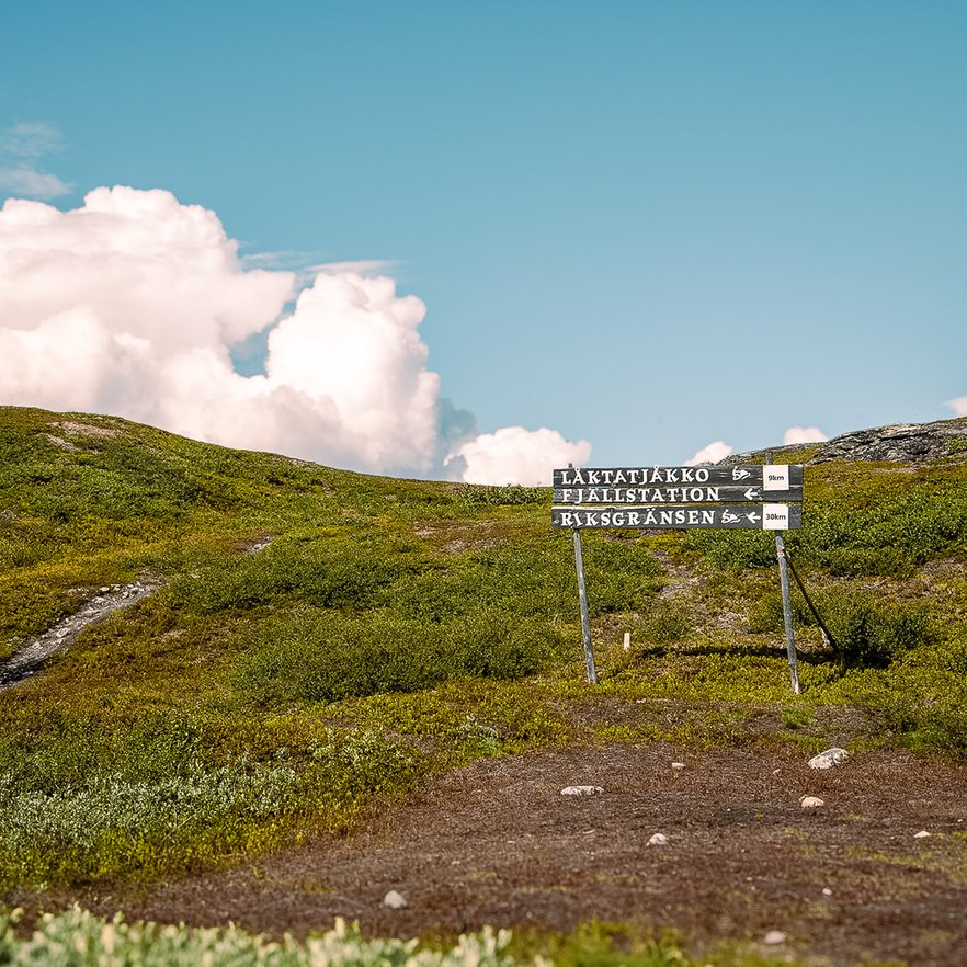 tr&auml;skylt med v&auml;gvisningar mot L&aring;ktatj&aring;kko fj&auml;llstation och Riksgr&auml;nsen