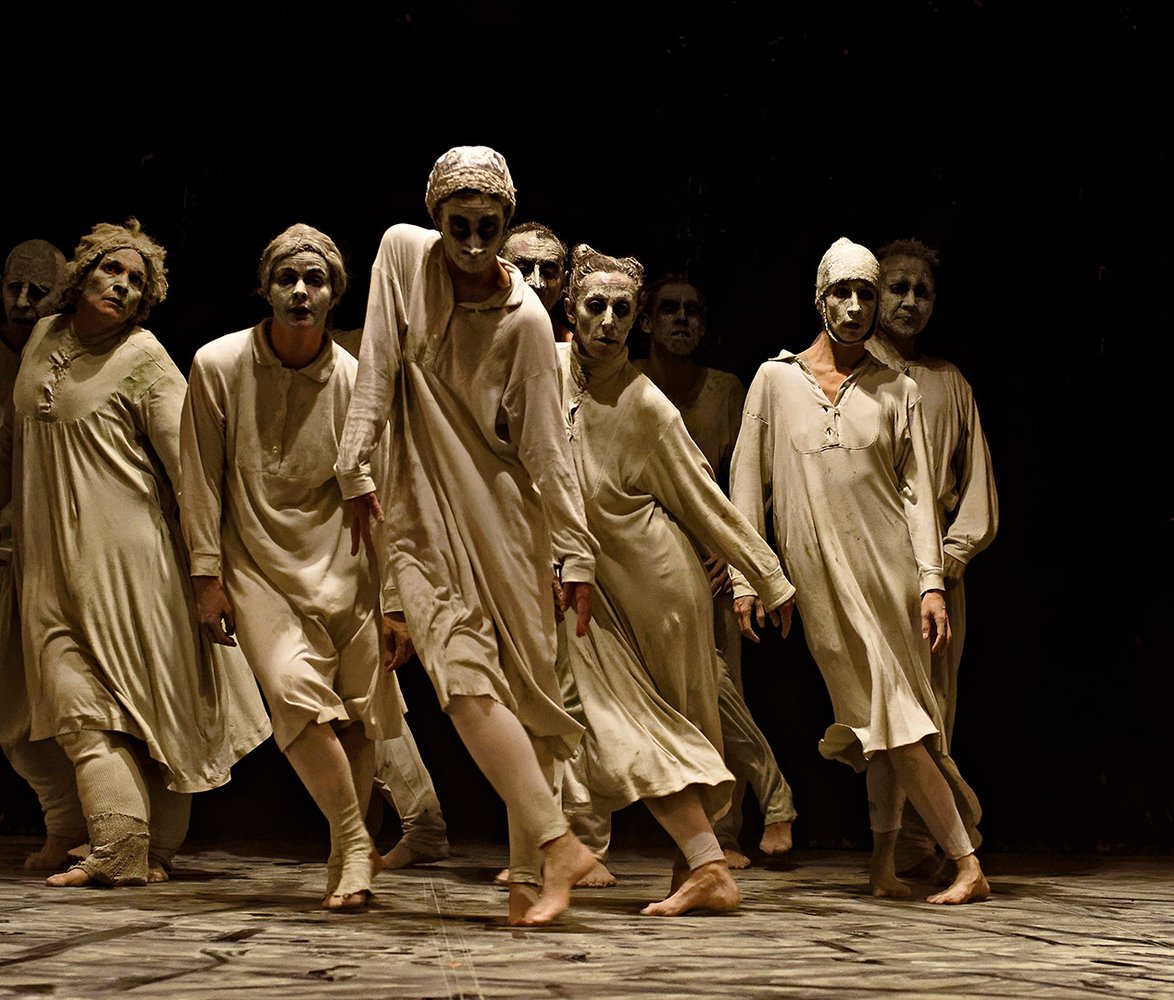 En grupp dansare med vitsminkade ansikten.