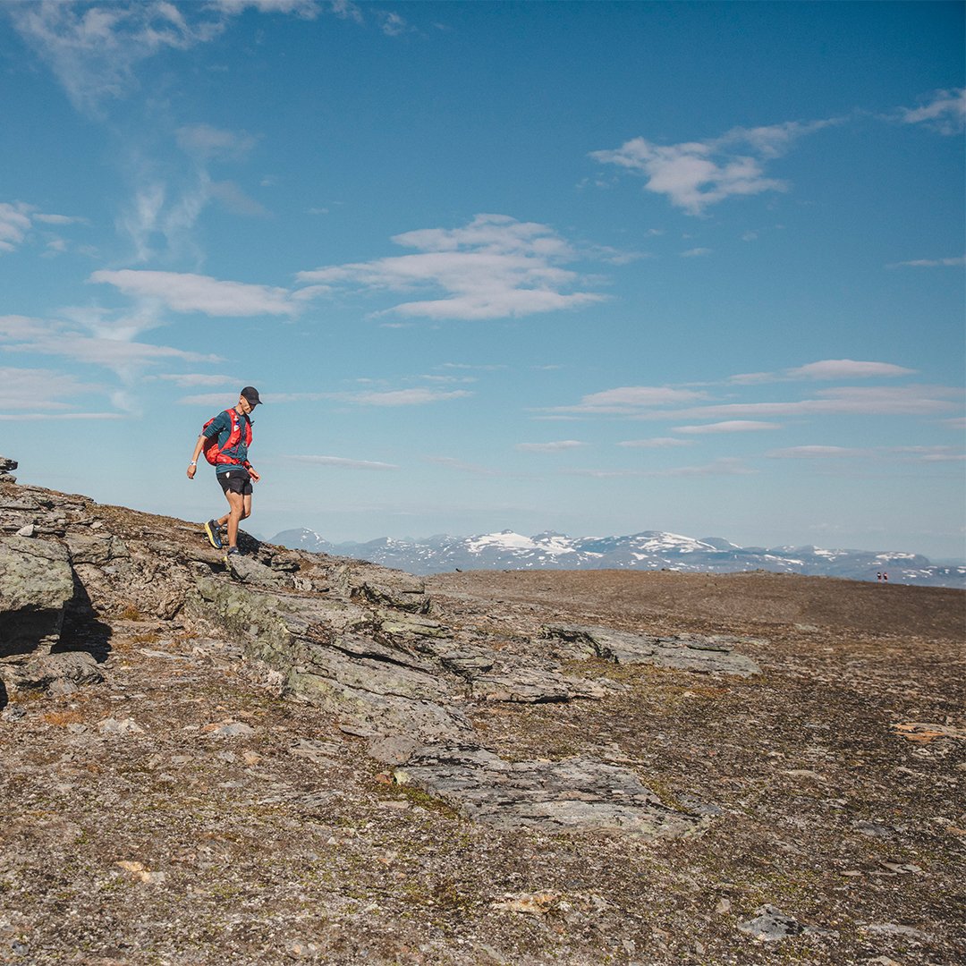 man vandrar p&aring; en fj&auml;lltopp i soligt v&auml;der