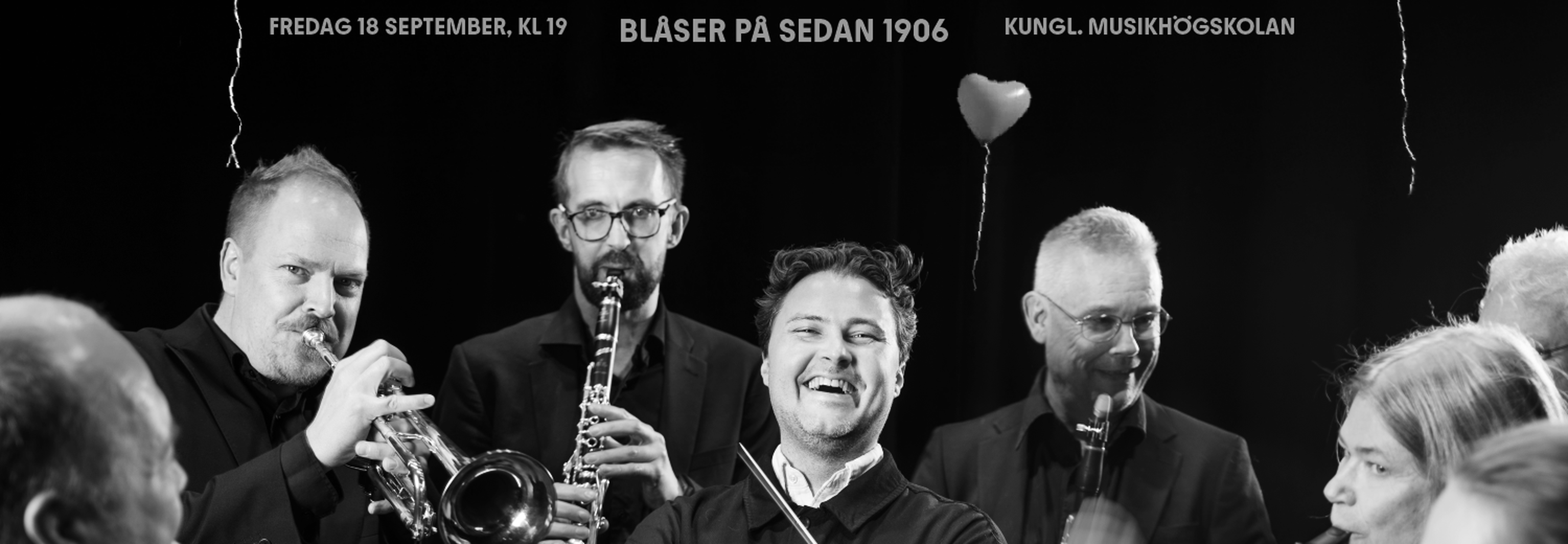Glad dirigent omgven av blåsmusiker