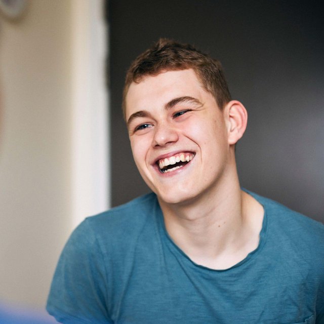 Happy young man talking with female nurse during hospital visit