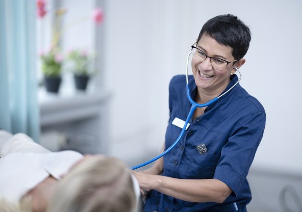 Kvinnlig läkare undersöker patient