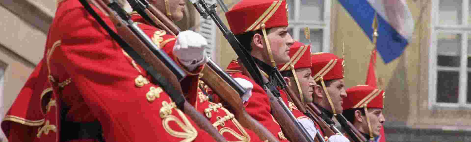 Beneath the Croatian flag members of the guard are lined up during a ceremony in front of the Croatian parliament building in Zagreb, 1991.