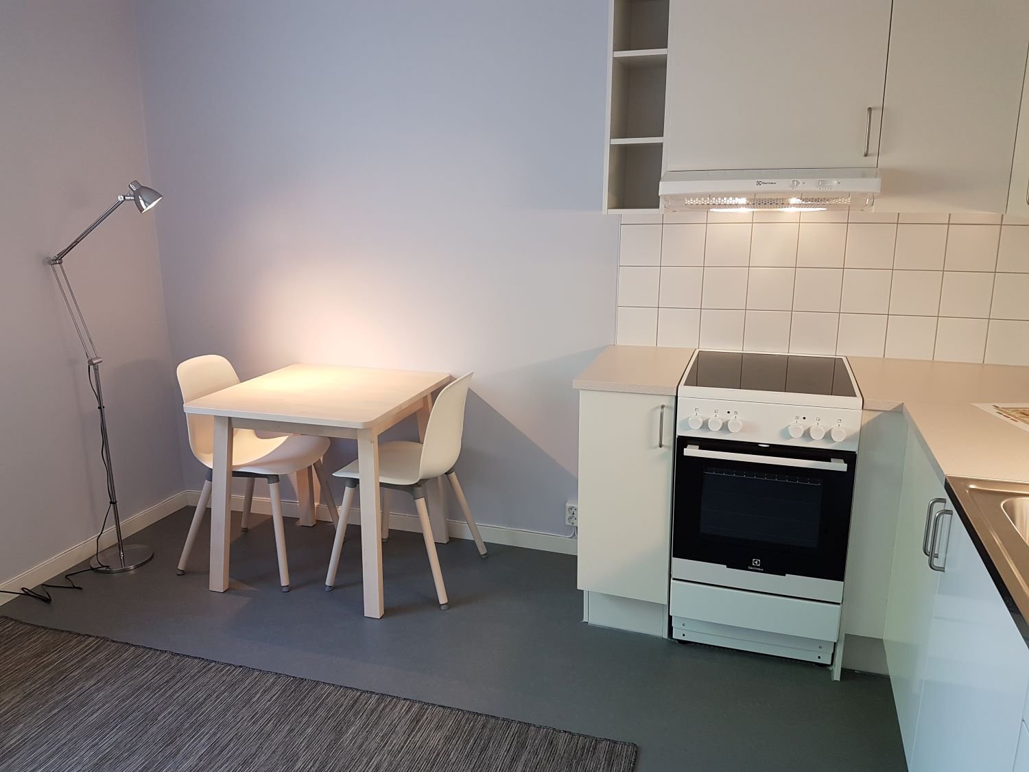 Studentroom with kitchen corner. A Stove, oven, table and chair.