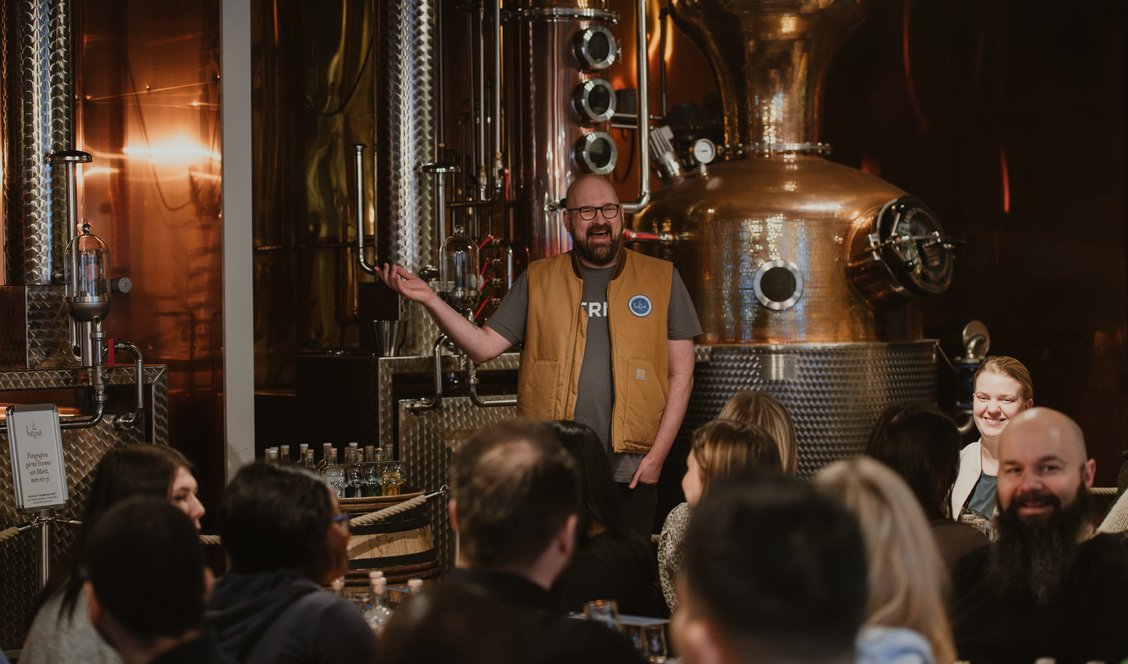 En av provningsledarna framför en av kopparpannorna i destilleriet i Dala