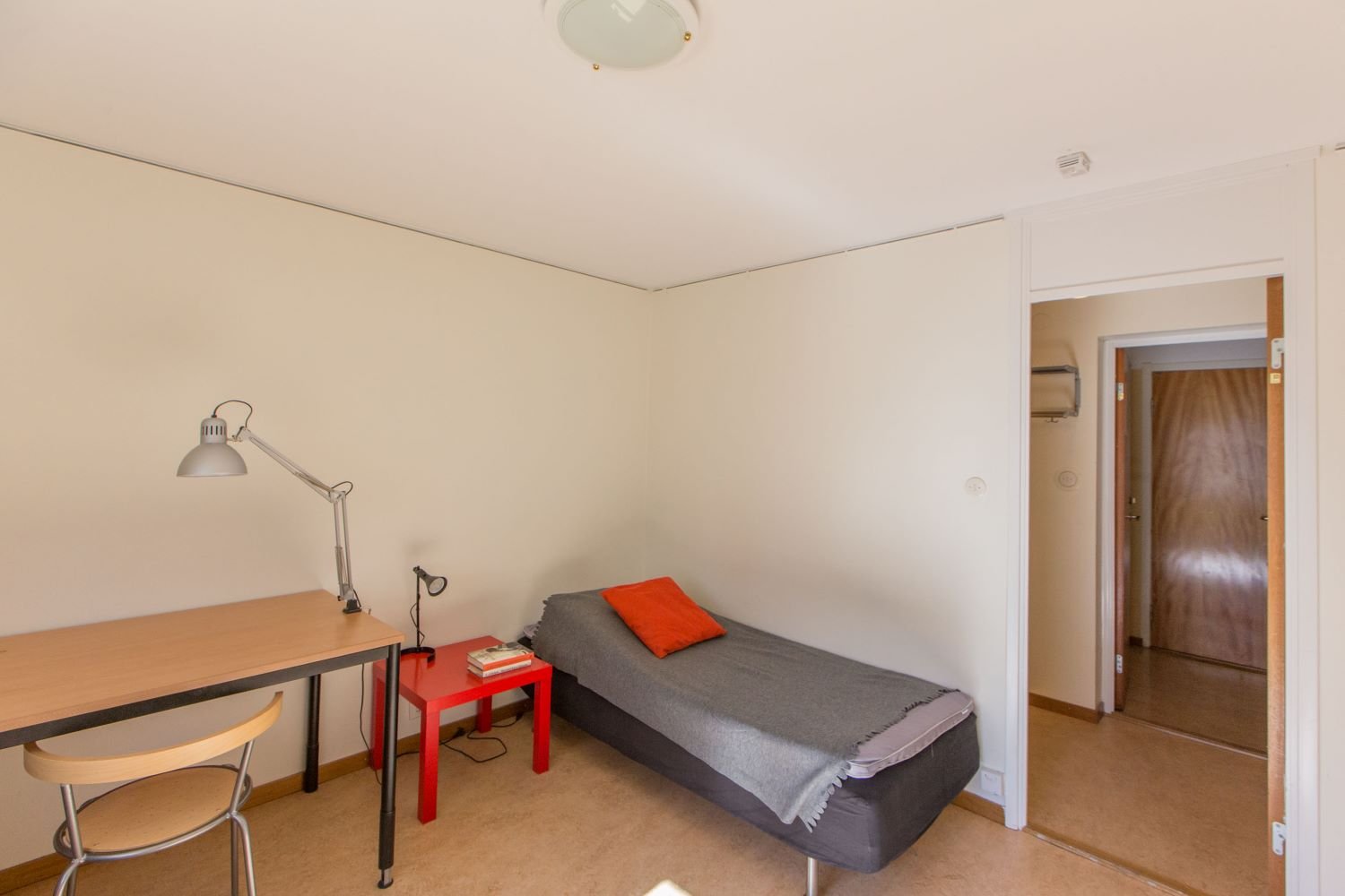 studentroom with desk, chair, bed and bedside table.