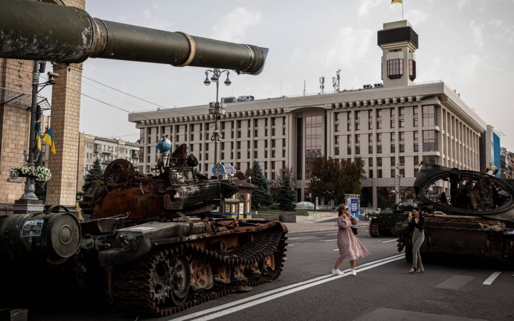 A woman seen taking a TikTok video in front of a destroyed Russian tank in Kyiv.